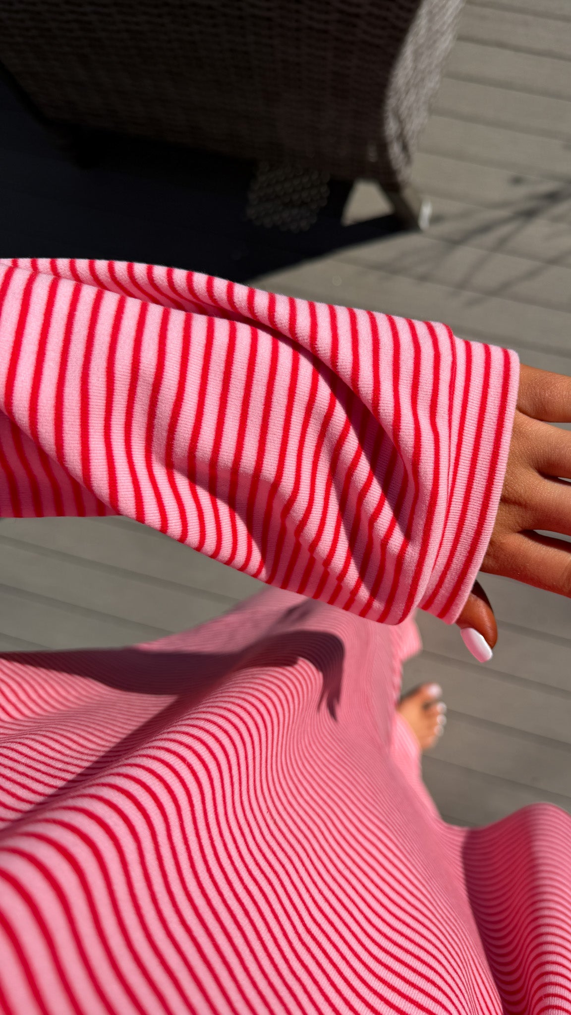 Close-up of a person wearing a red and white striped shirt with a blurred background