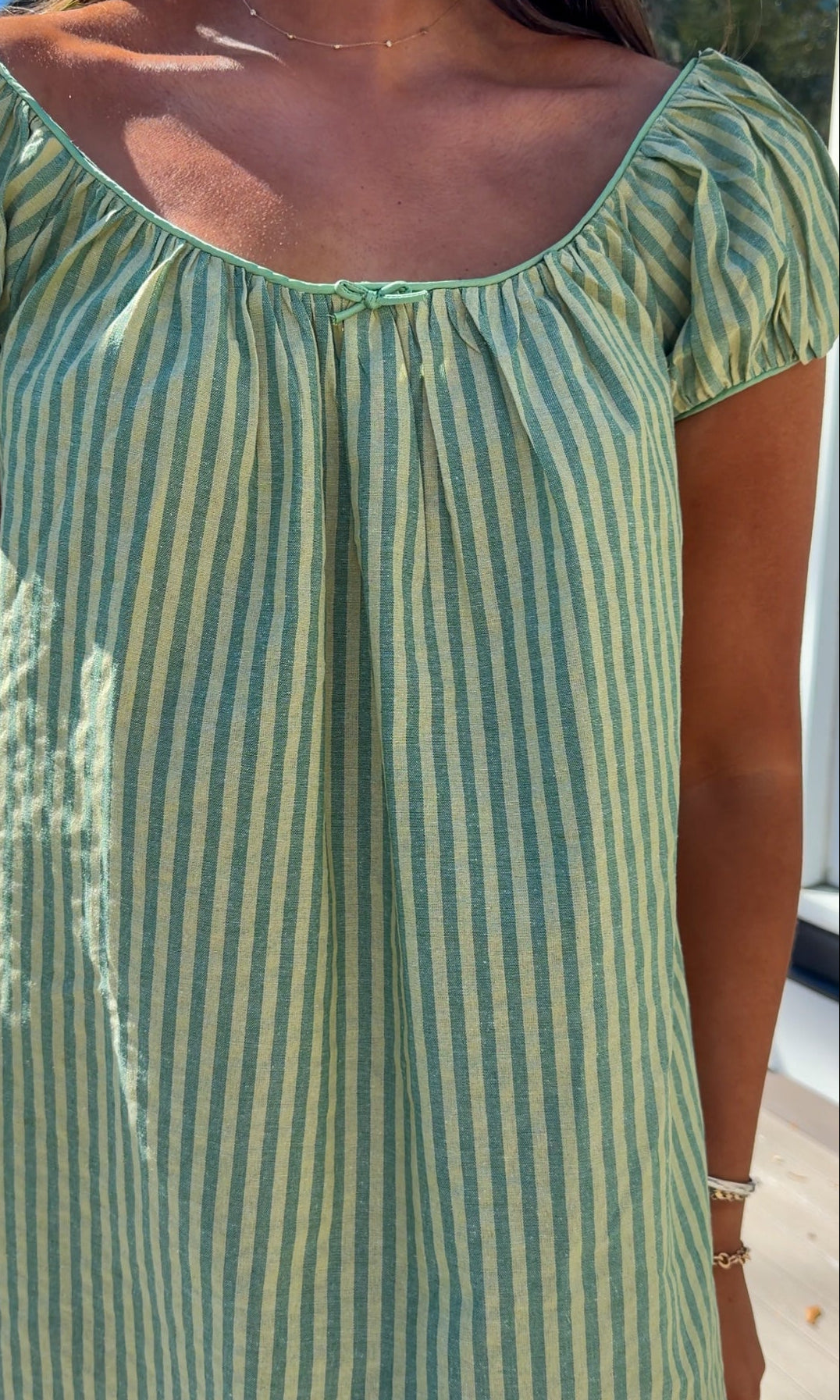 green striped babydoll mini dress with gathered neckline and pockets