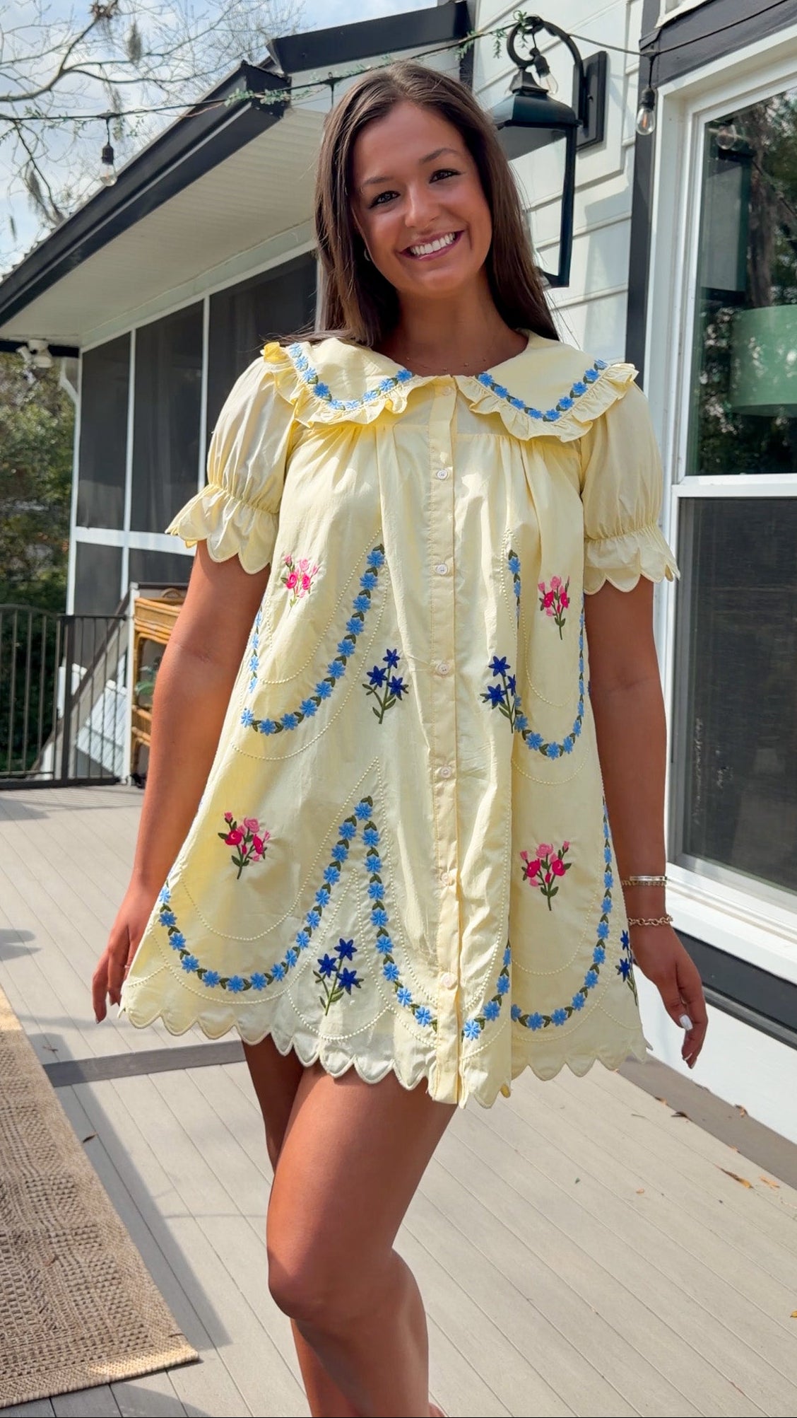 yellow mini dress with multicolor floral embroidery, ruffle collar, puff sleeves, and scalloped hem