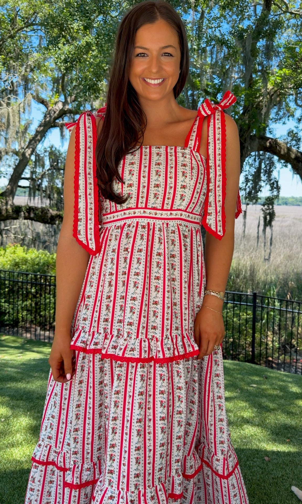 Woman wearing a red and white dress with a scenic background