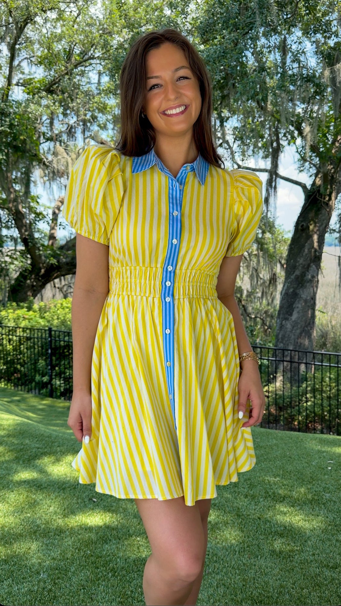 Yellow and ivory striped mini dress featuring a contrast blue collar and button placket, short puff sleeves, a smocked waist, side pockets, and a lightweight lined silhouette.