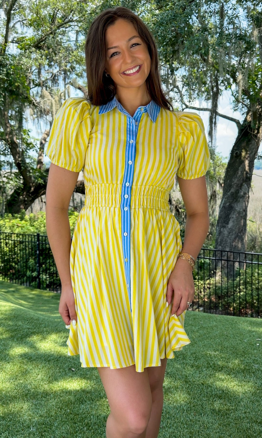 Yellow and ivory striped mini dress featuring a contrast blue collar and button placket, short puff sleeves, a smocked waist, side pockets, and a lightweight lined silhouette.