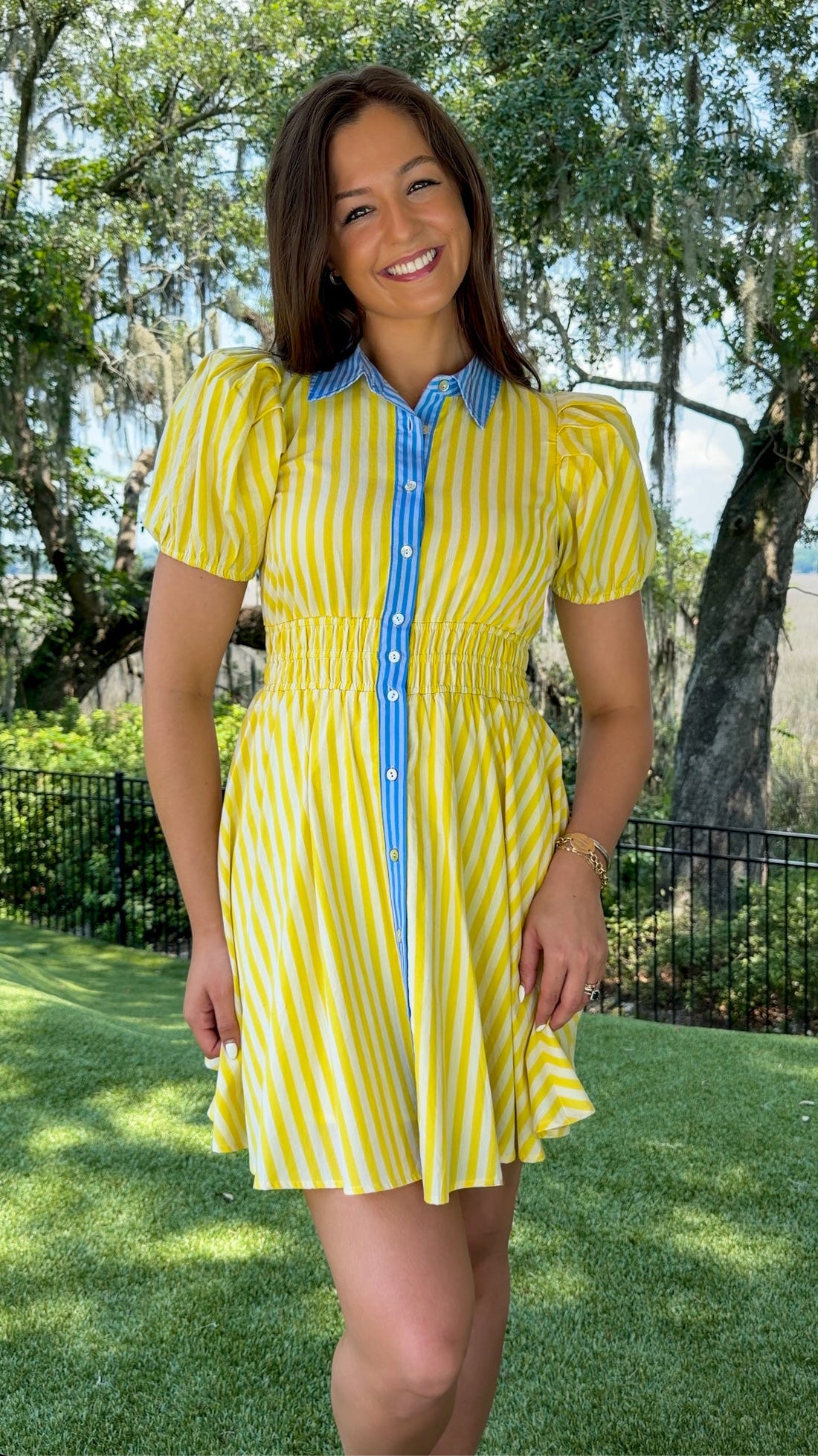 Yellow and ivory striped mini dress featuring a contrast blue collar and button placket, short puff sleeves, a smocked waist, side pockets, and a lightweight lined silhouette.