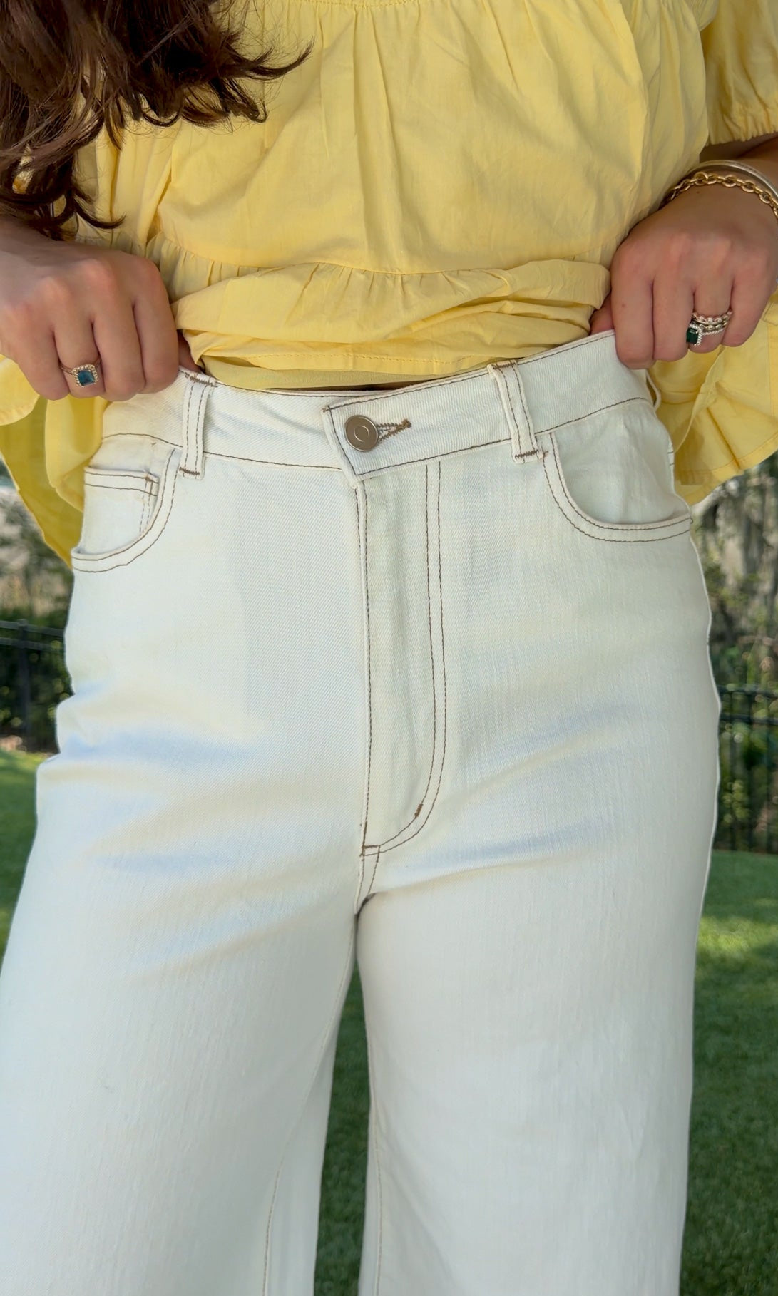 White high-rise wide leg denim jeans featuring contrast stitching, a cropped raw hem, front and back pockets, and a flattering structured fit.