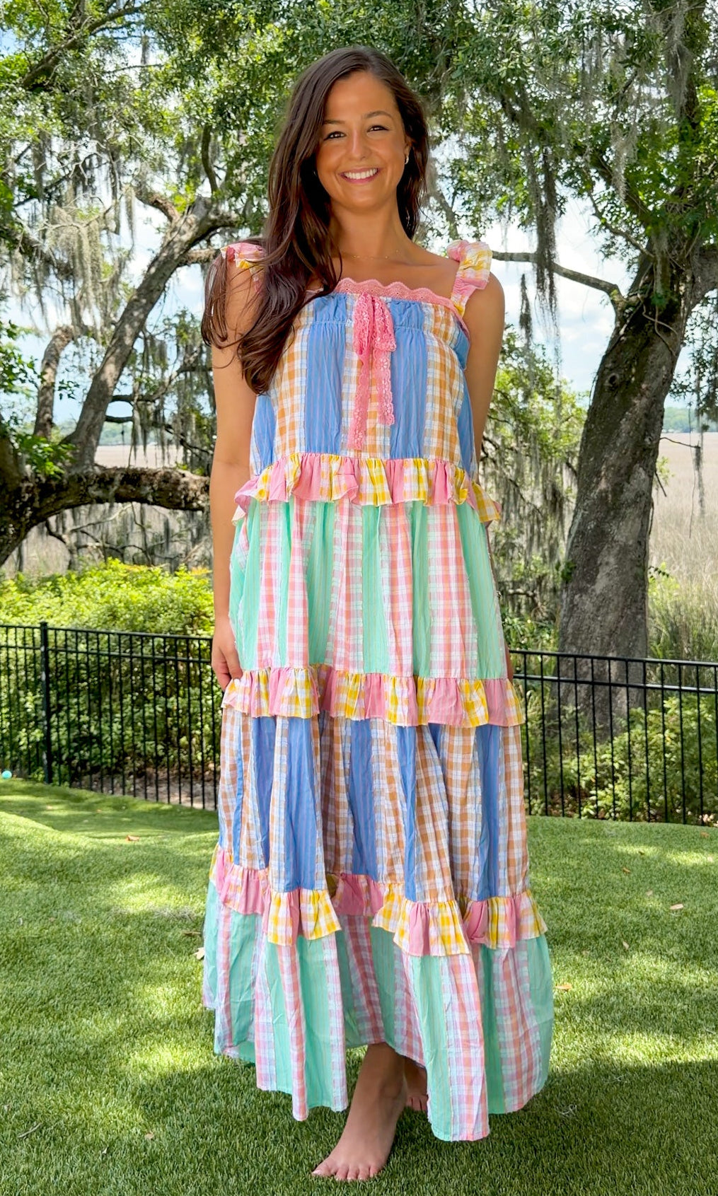 Pastel patchwork maxi dress featuring mixed check and stripe prints in pink, blue, yellow, and mint with ruffle straps, heart-shaped front pockets, lace trim, and a relaxed flowy silhouette.