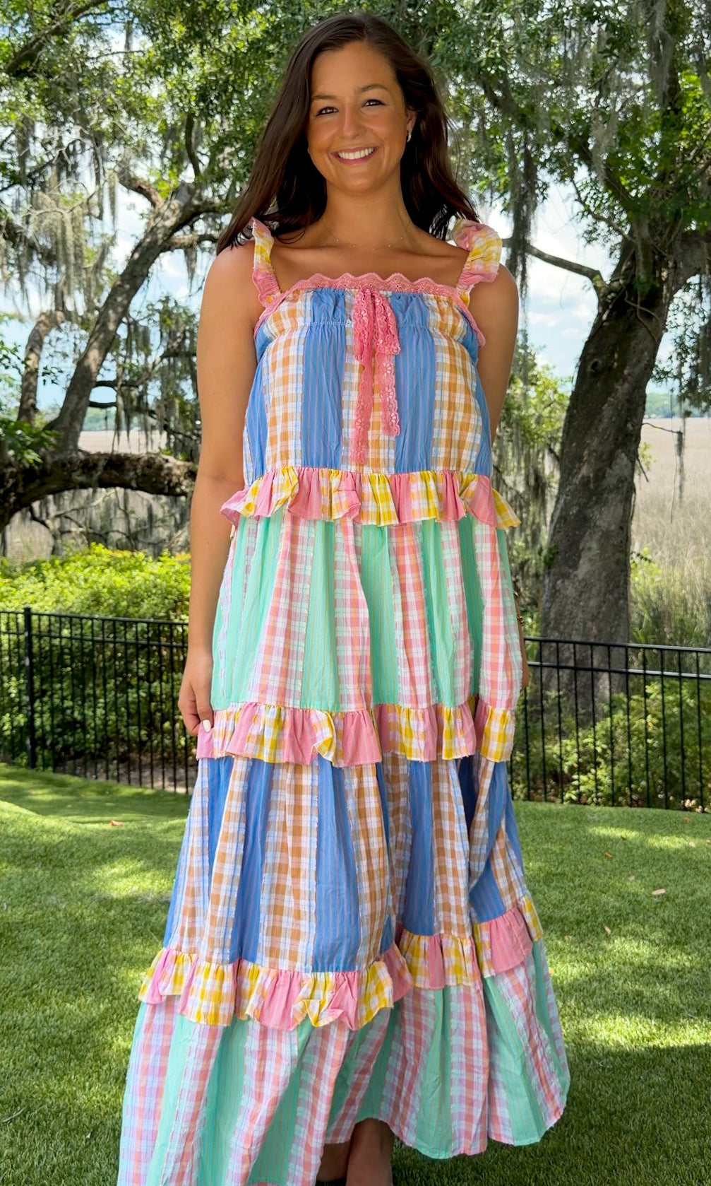Pastel patchwork maxi dress featuring mixed check and stripe prints in pink, blue, yellow, and mint with ruffle straps, heart-shaped front pockets, lace trim, and a relaxed flowy silhouette.