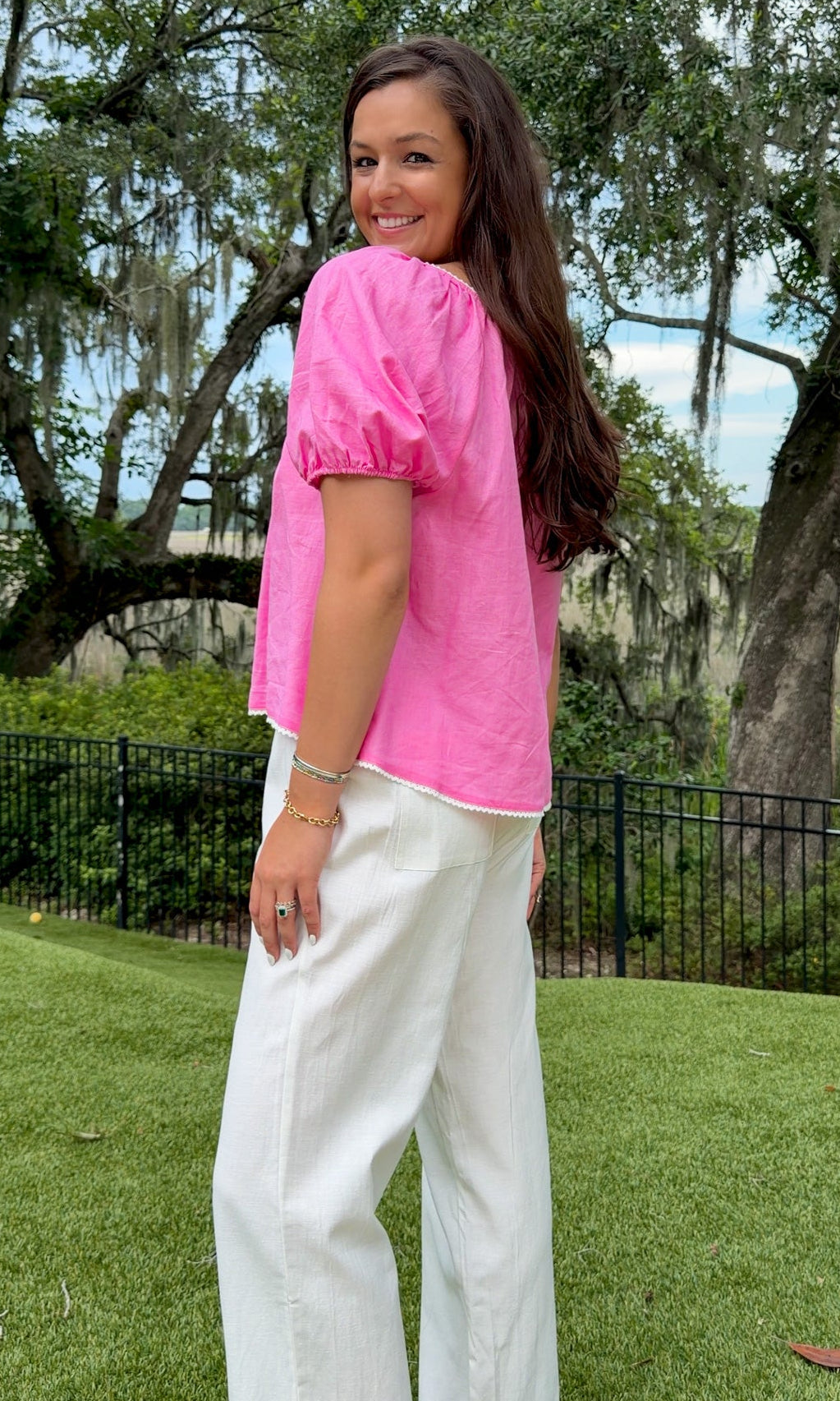 White full-length straight-leg pants featuring an elastic drawstring waistband, side and back patch pockets, delicate ruffle trim at the hem, and a relaxed, lightweight fit.
