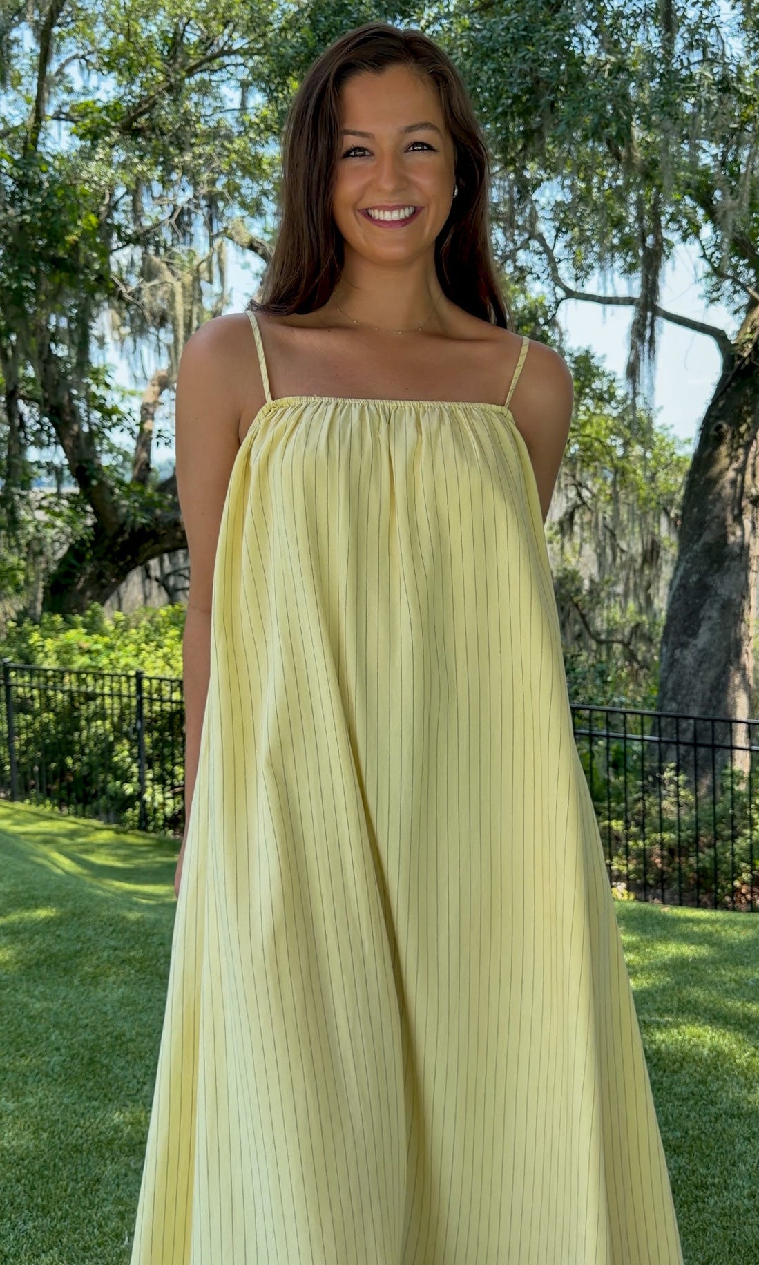 Butter yellow pinstripe maxi dress featuring adjustable spaghetti straps, a gathered square neckline, and a relaxed flowy silhouette in a lightweight woven fabric.