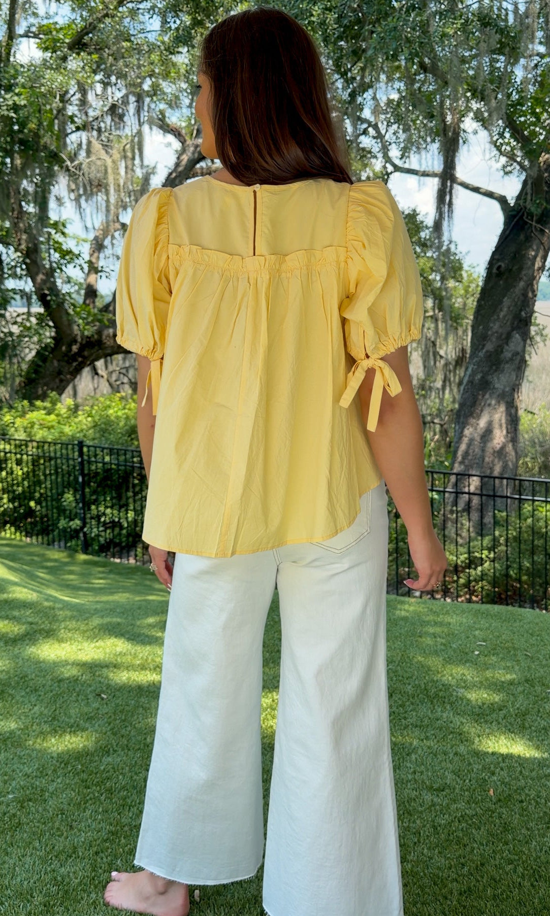 White high-rise wide leg denim jeans featuring contrast stitching, a cropped raw hem, front and back pockets, and a flattering structured fit.