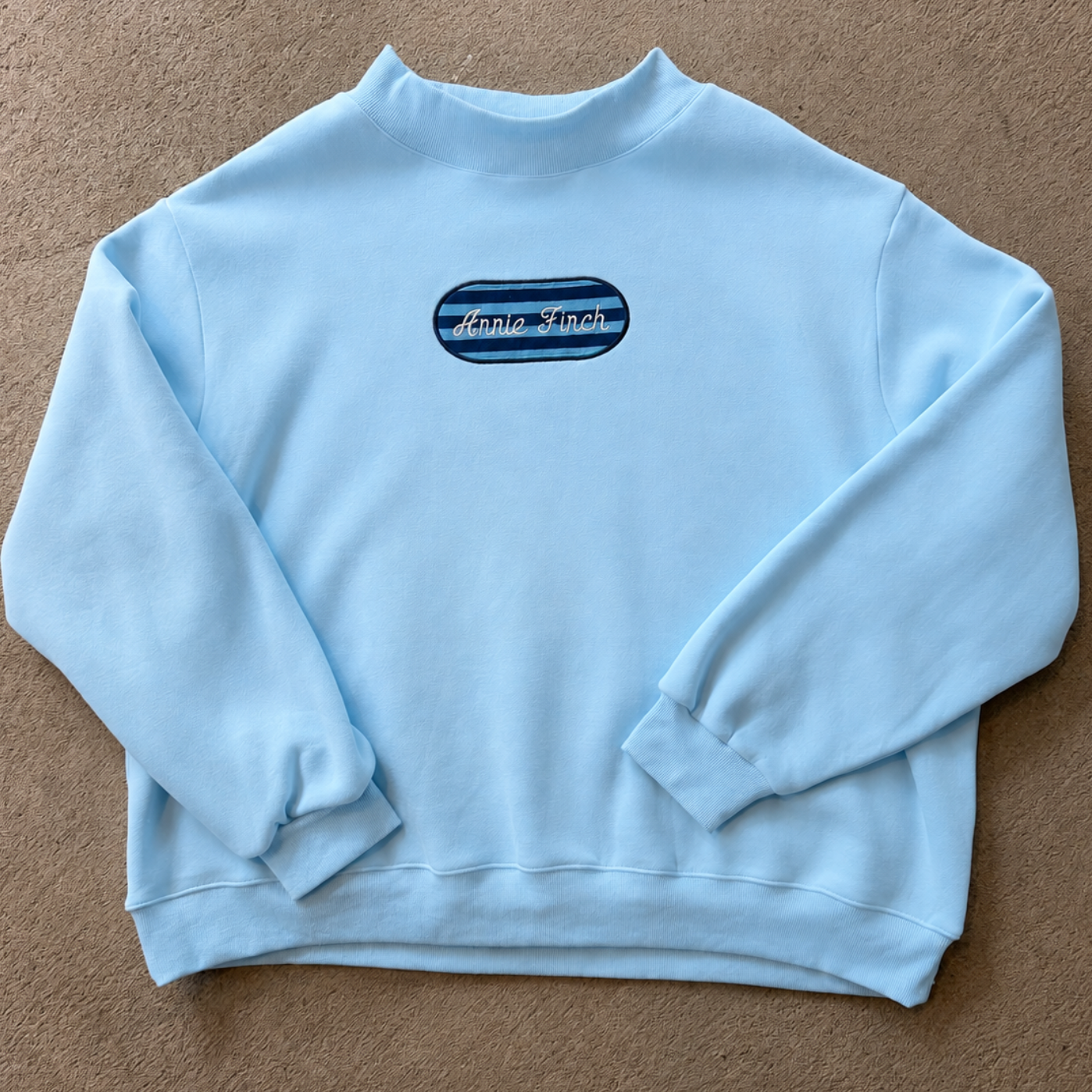 light blue mockneck sweatshirt with patch striped with embroidered annie finch