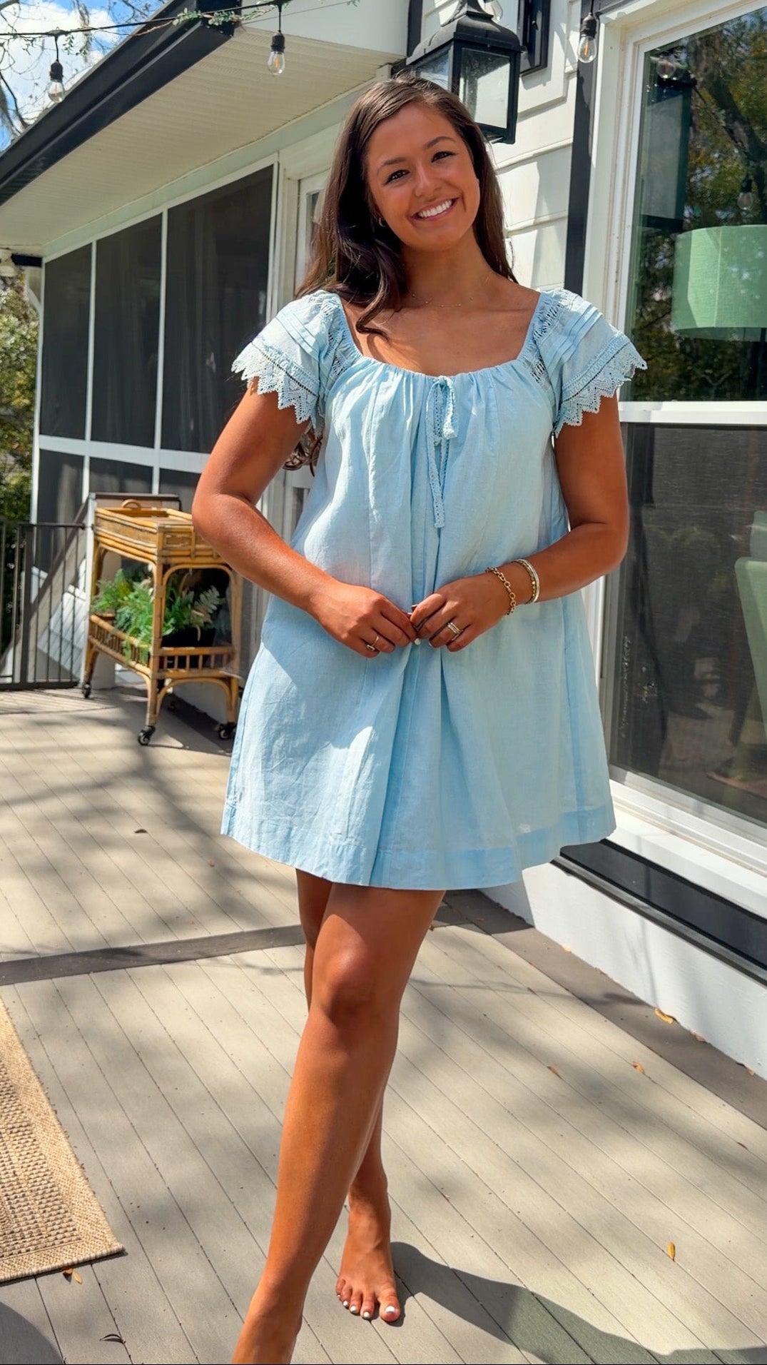 light blue linen blend mini dress with eyelet lace trim sleeves and tie neckline