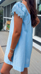 light blue linen blend mini dress with eyelet lace trim sleeves and tie neckline