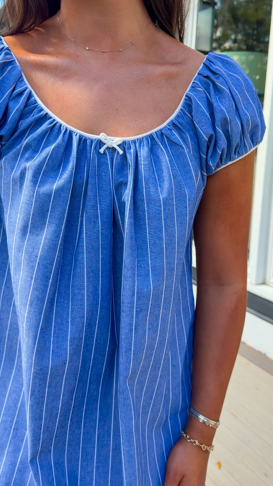 blue stripe babydoll mini dress with gathered neckline short sleeves and side pockets