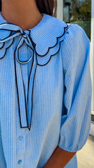 light blue striped mini dress with scalloped collar contrast trim bow tie and button front