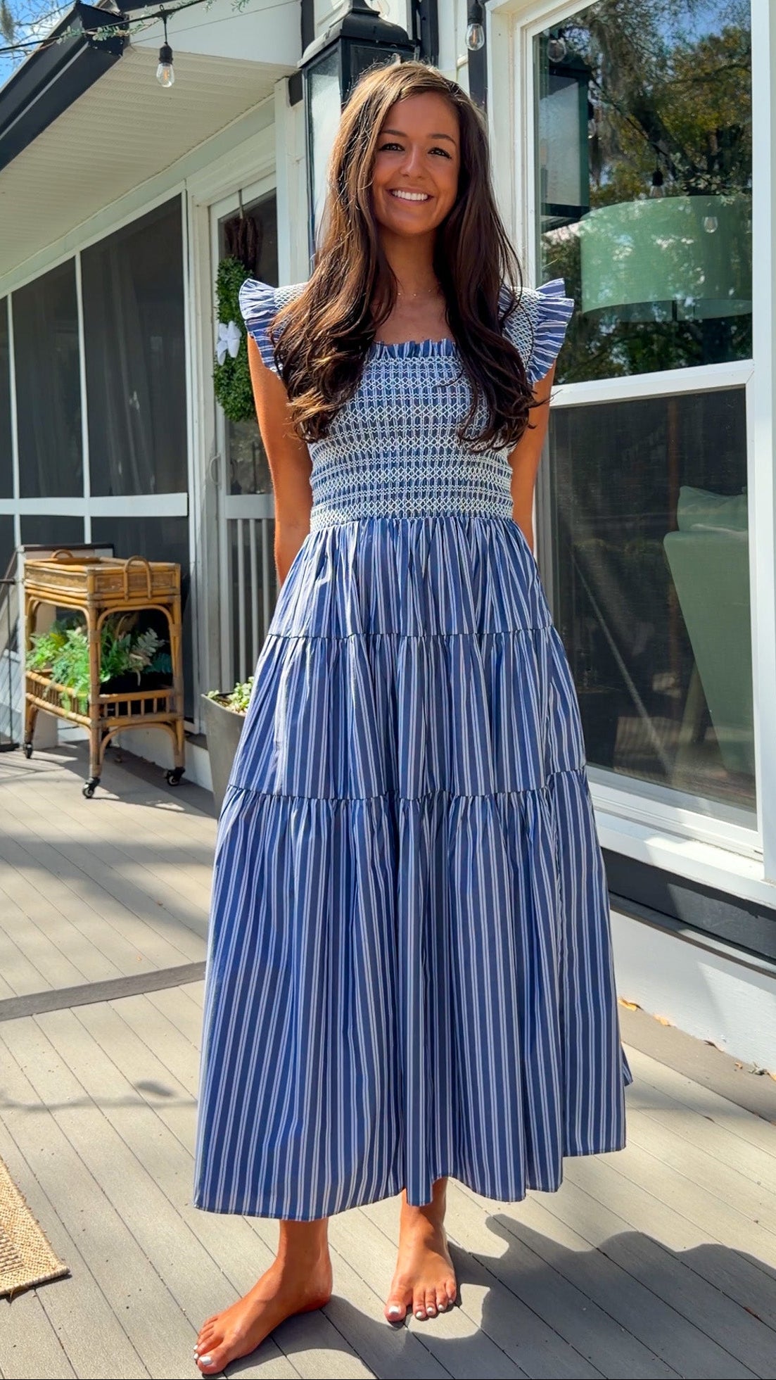 navy striped midi dress with smocked bodice ruffle sleeves and tiered skirt
