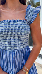 navy striped midi dress with smocked bodice ruffle sleeves and tiered skirt