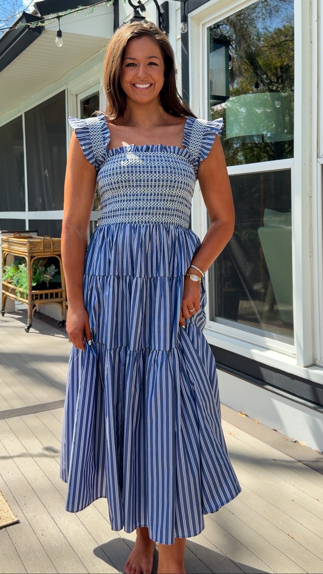 navy striped midi dress with smocked bodice ruffle sleeves and tiered skirt