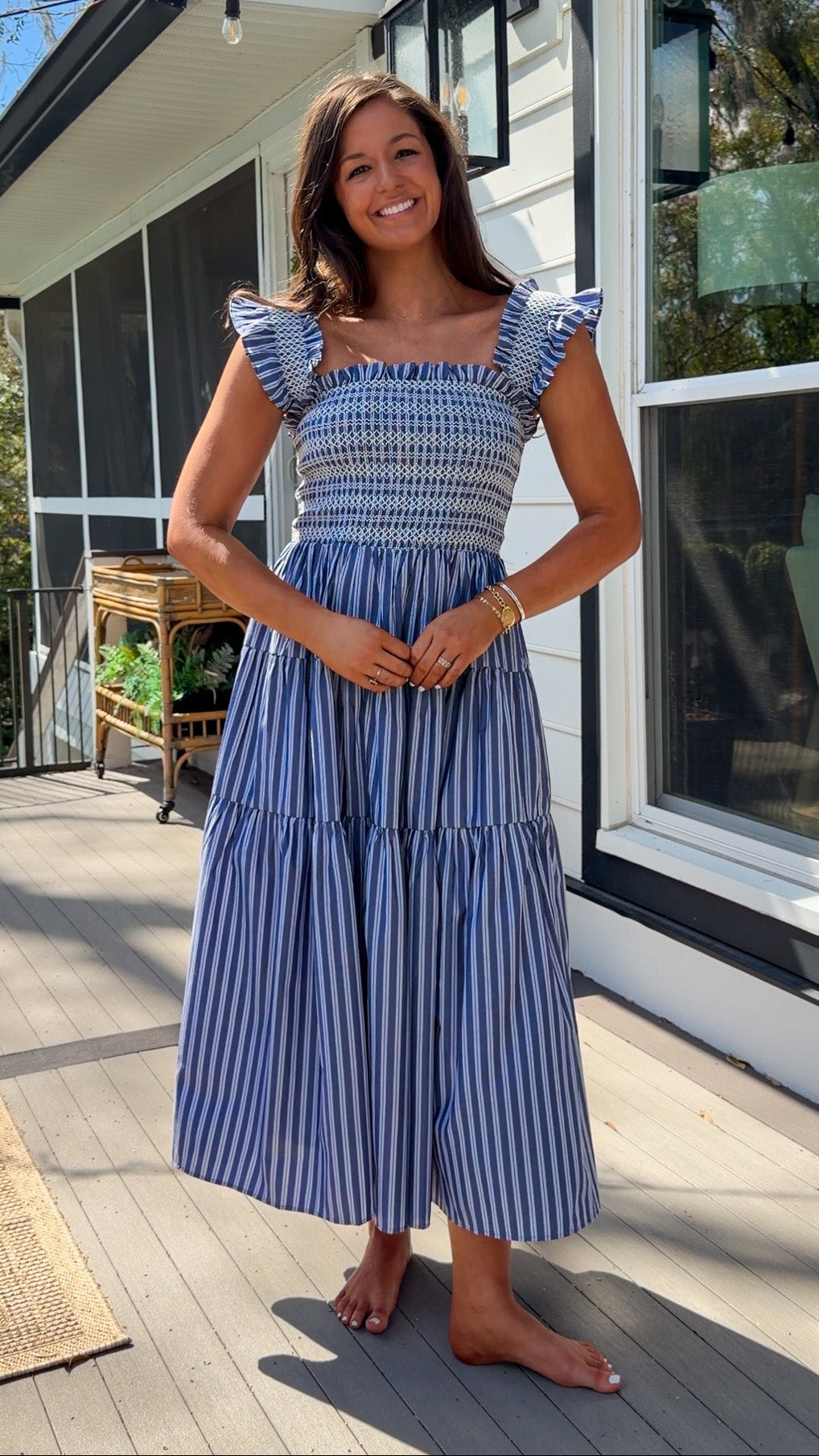 navy striped midi dress with smocked bodice ruffle sleeves and tiered skirt