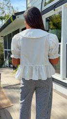 white cotton blouse with peter pan collar, puff sleeves, tie front bow and peplum hem