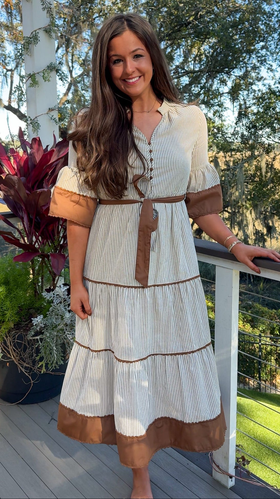 beige midi dress with brown stripes and details and belt front 