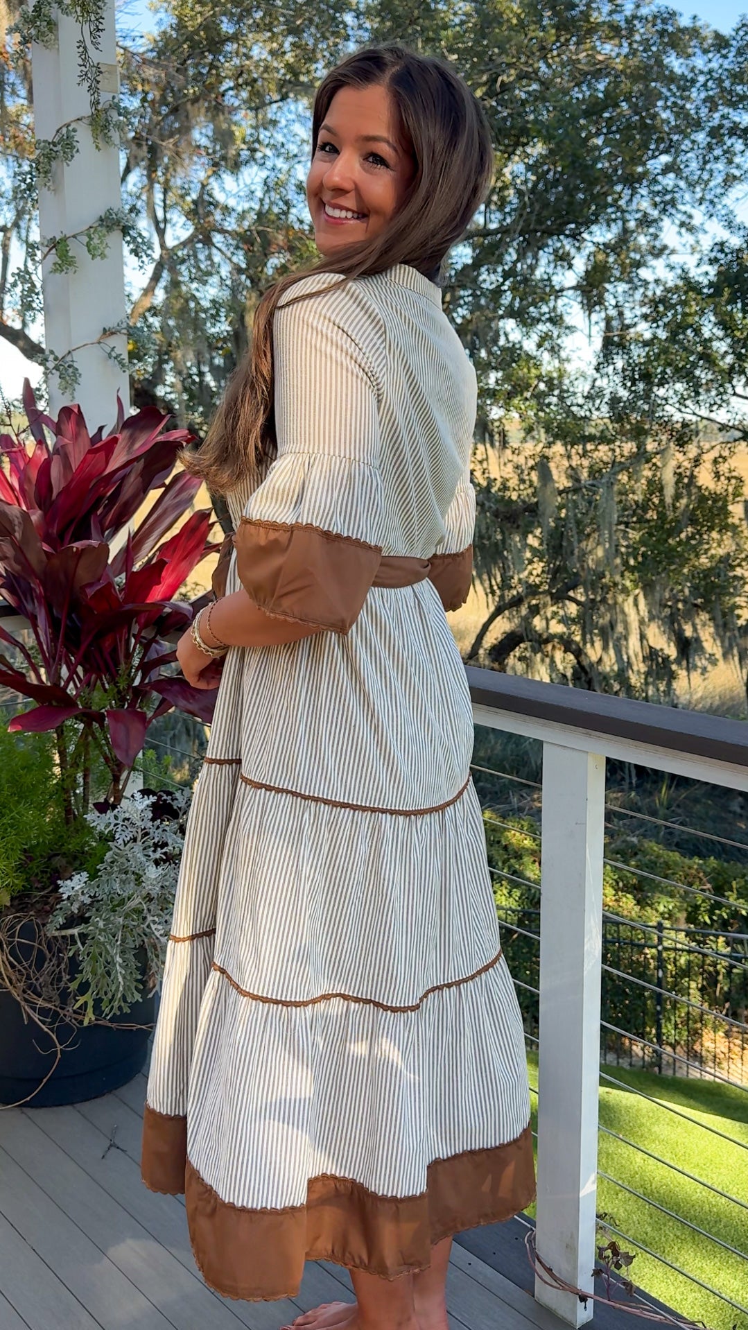 beige midi dress with brown stripes and details and belt side 