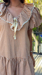 gingham orange and brown mini dress with ruffle collar and lace trim front close view