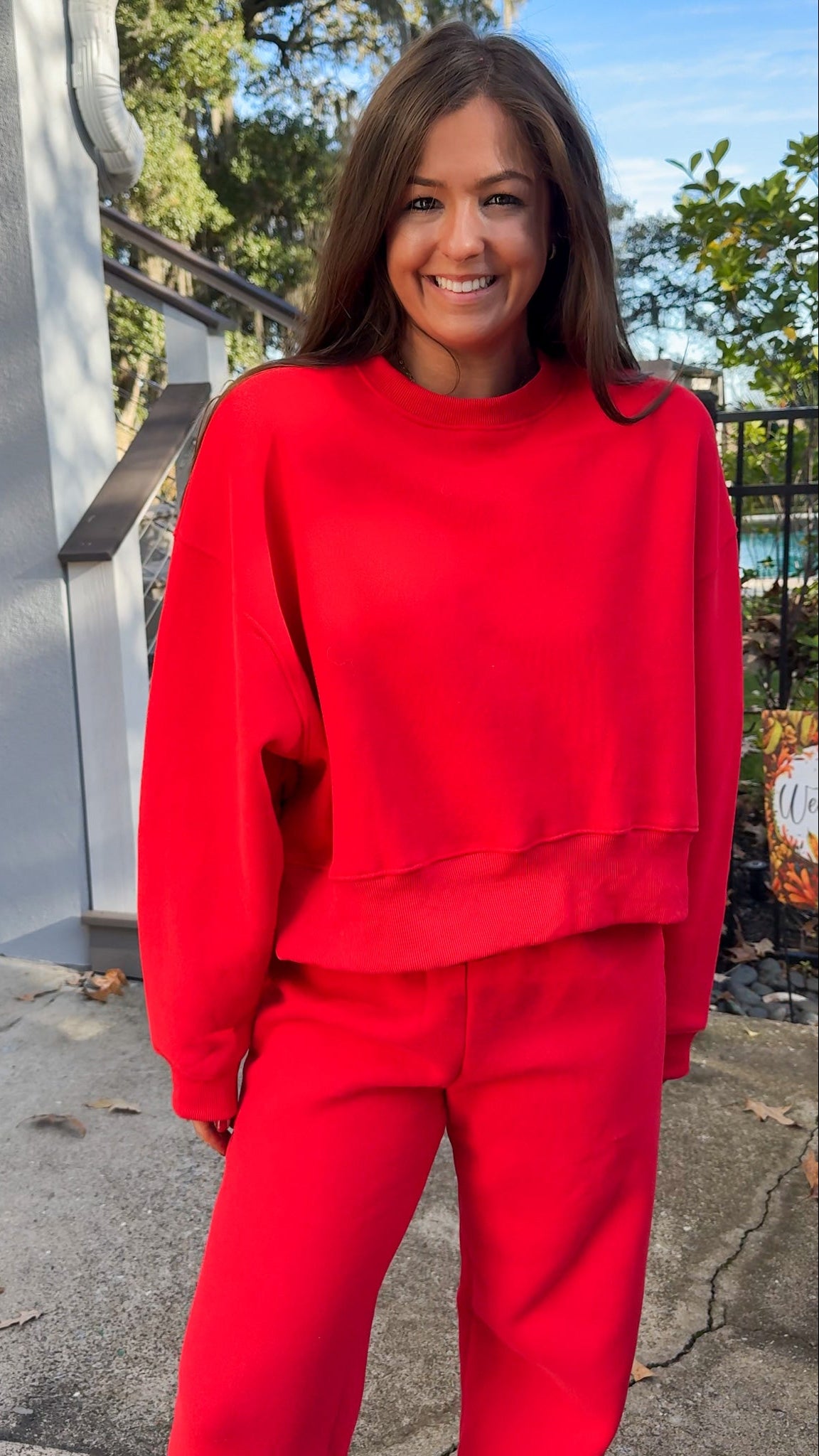 matching red sweatpants and sweatshirt comfy cozy loungewear. elastic waist band and slightly cropped oversized long sleeve top close