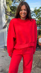 matching red sweatpants and sweatshirt comfy cozy loungewear. elastic waist band and slightly cropped oversized long sleeve top close