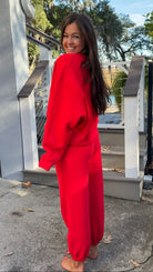 matching red sweatpants and sweatshirt comfy cozy loungewear. elastic waist band and slightly cropped oversized long sleeve top side view