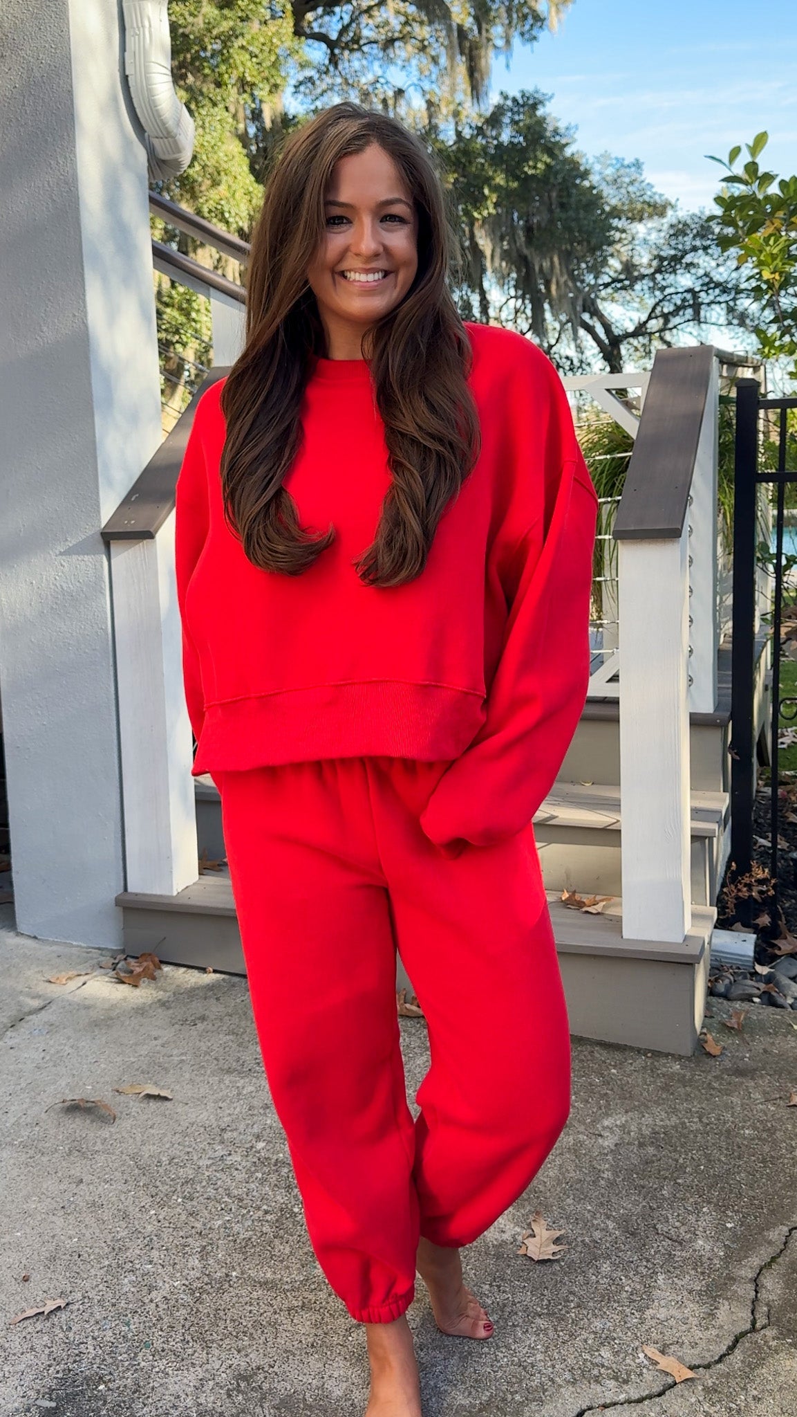 matching red sweatpants and sweatshirt comfy cozy loungewear. elastic waist band and slightly cropped oversized long sleeve top far 2