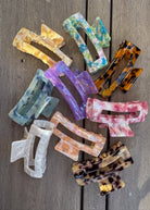 Colorful hair clips on a wooden surface