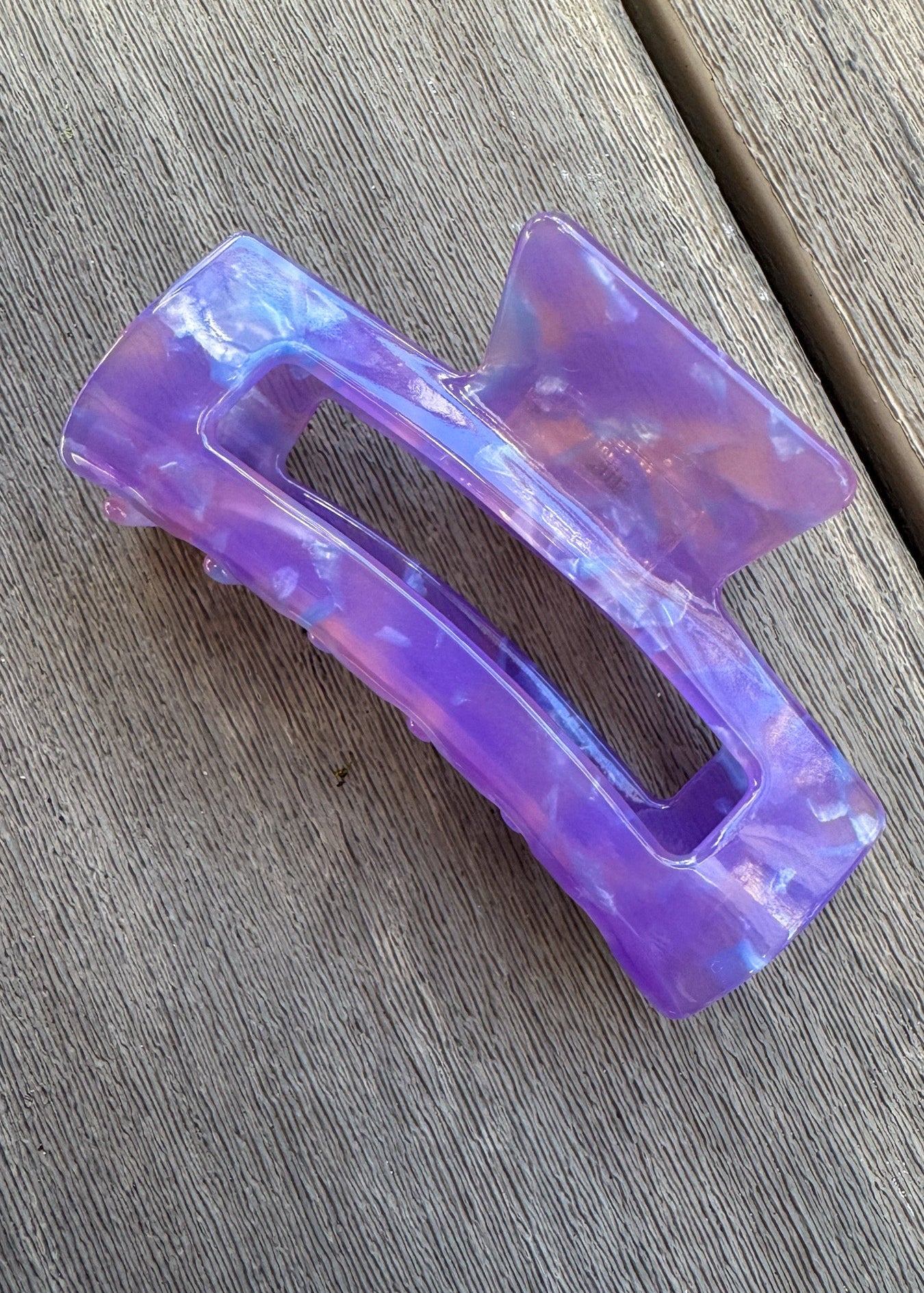 Purple hair clip on a wooden surface