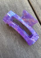 Purple hair clip on a wooden surface