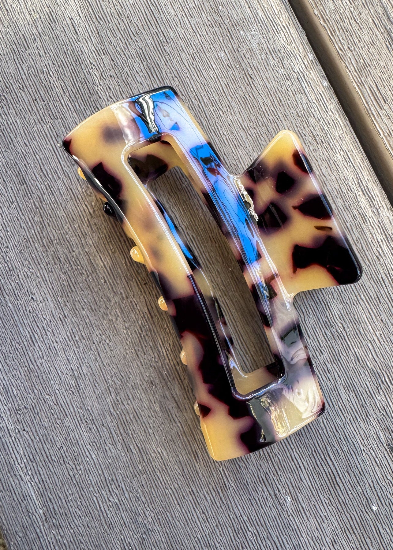 Tortoiseshell patterned hair clip on a wooden surface