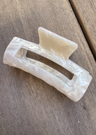 White plastic clip on a wooden surface