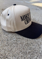 Beige and black cap with text on a concrete surface