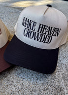 Cap with 'MAKE HEAVEN CROWDED' text on a textured surface