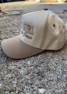 Beige cap with text on a concrete surface