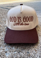 Cap with 'God is Good All the time' text on a concrete surface, trucker hat, christian trucker hat brown