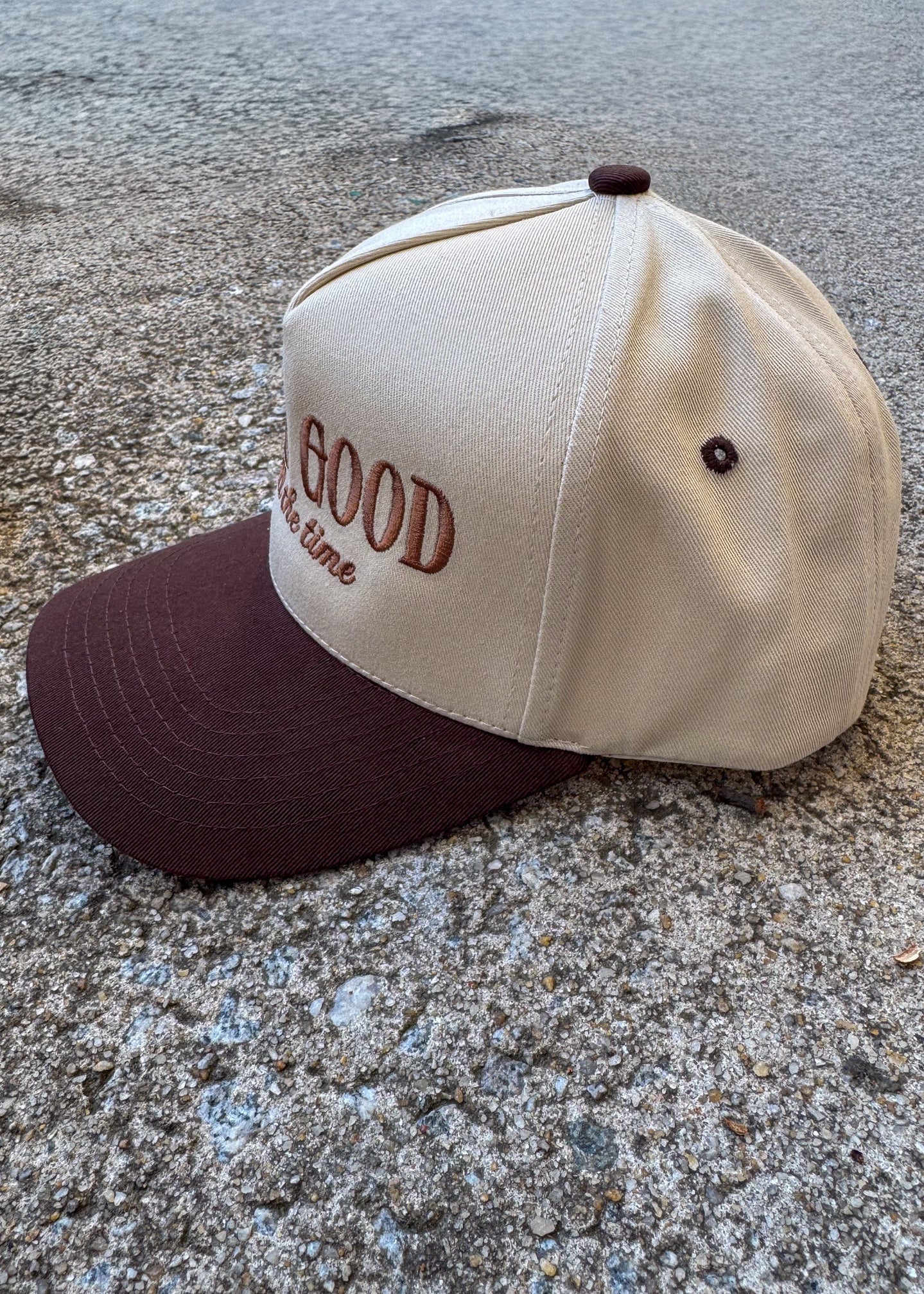 Cap with 'God is Good All the time' text on a concrete surface, trucker hat, christian trucker hat