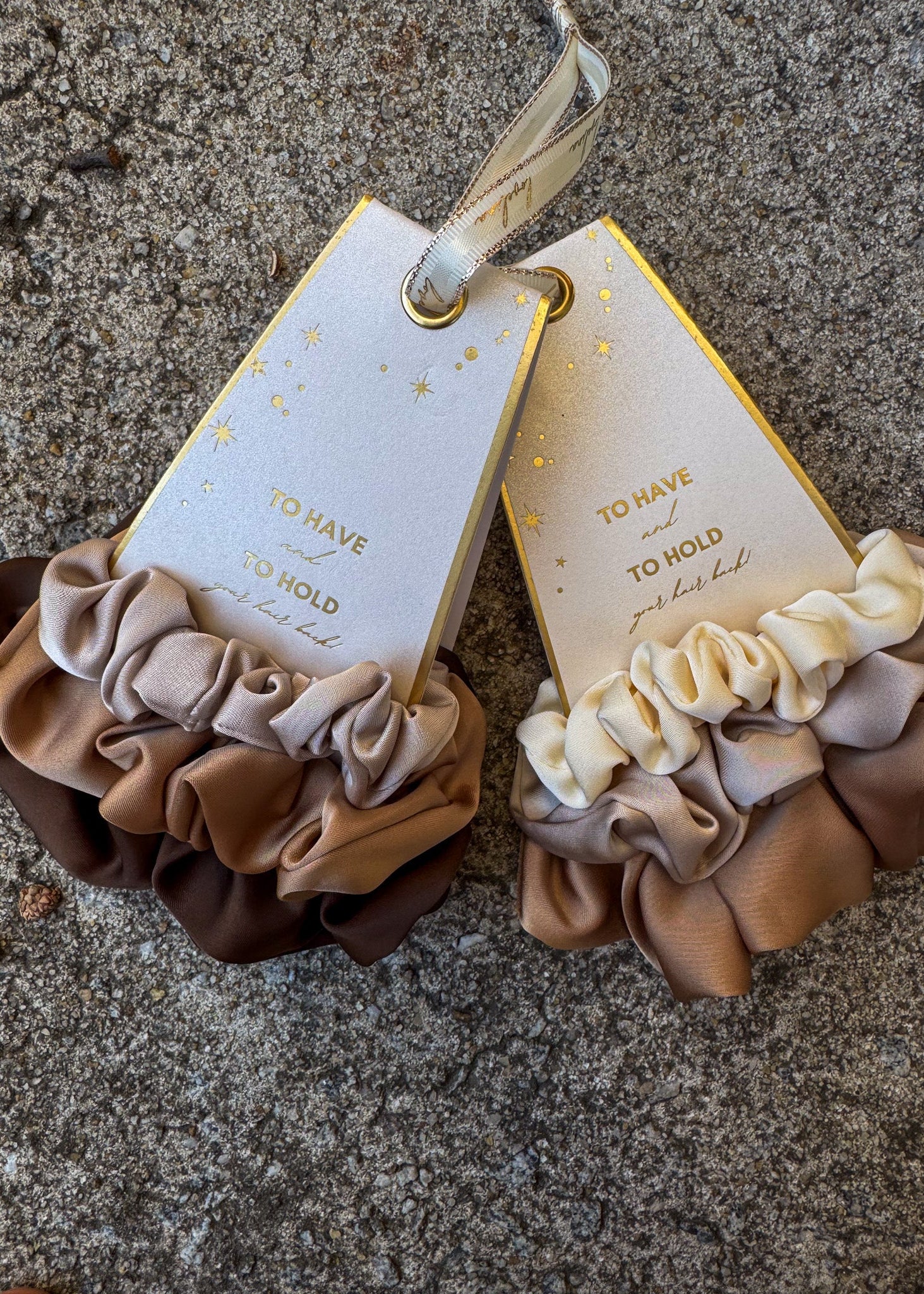 Pair of scrunchies with matching tags on a textured surface