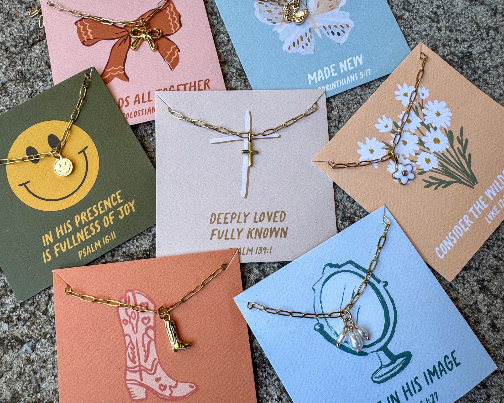 Collection of necklaces on cards with various designs and text.