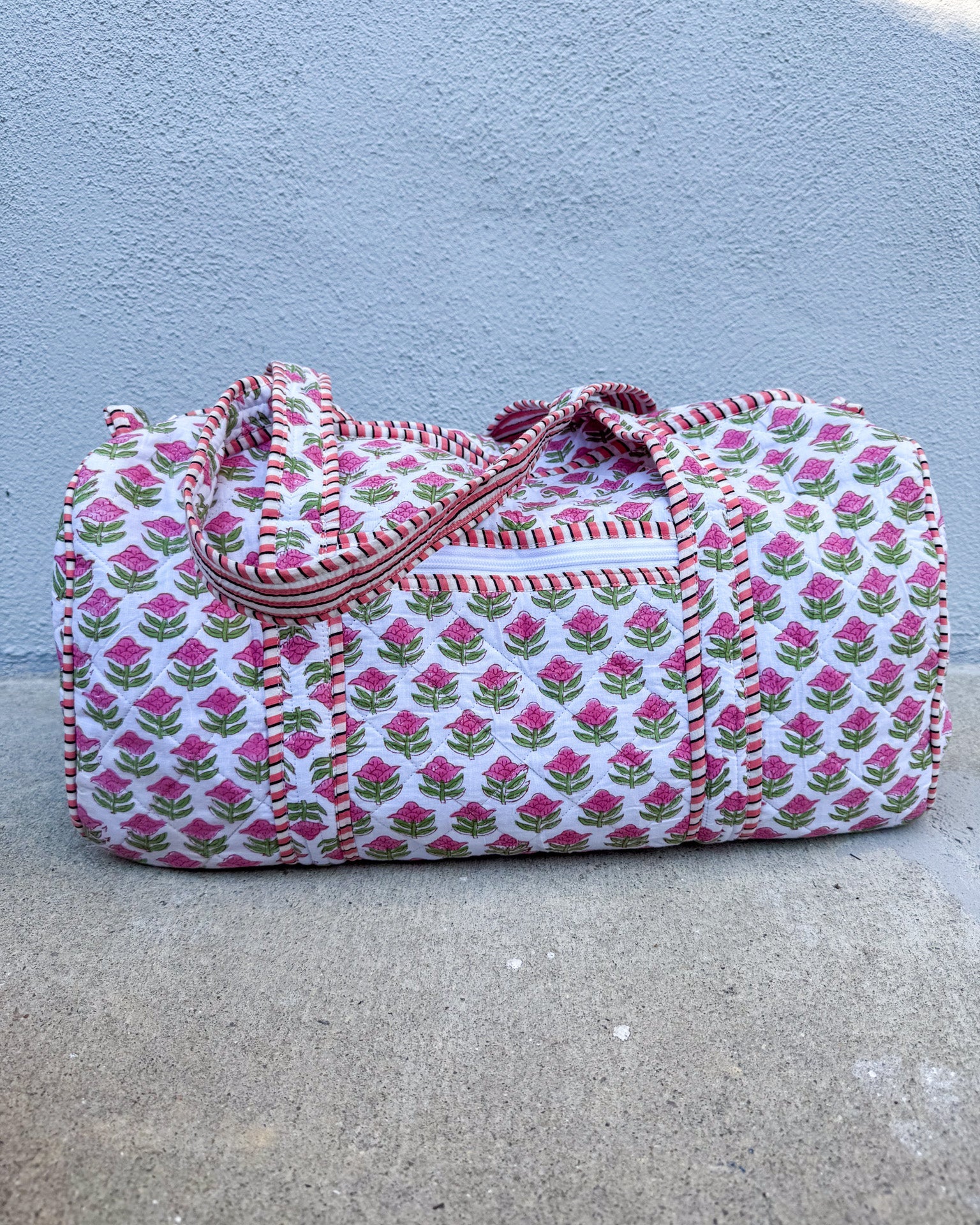 Floral patterned duffel bag on a concrete surface