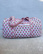 Floral patterned duffel bag on a concrete surface