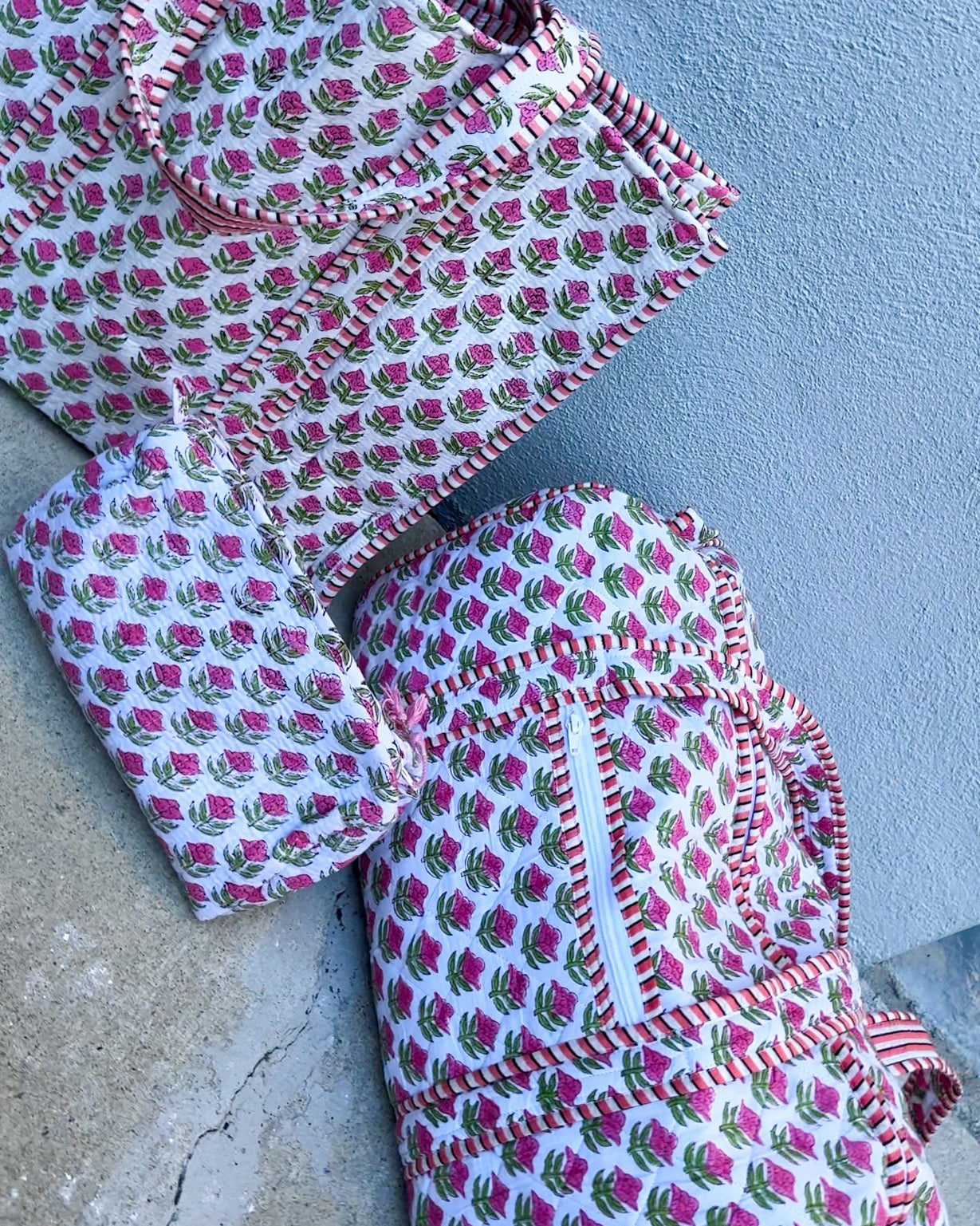 Set of patterned fabric pieces on a concrete surface with a light blue wall background