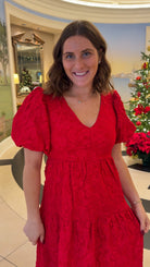 red jacquard maxi dress with puff sleeves and tiered skirt bottom and open back tie bow v neck holiday christmas dress closeup