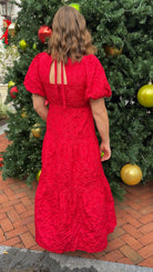 red jacquard maxi dress with puff sleeves and tiered skirt bottom and open back tie bow v neck holiday christmas dress