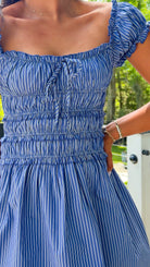 Blue striped dress worn by a person with a blurred background