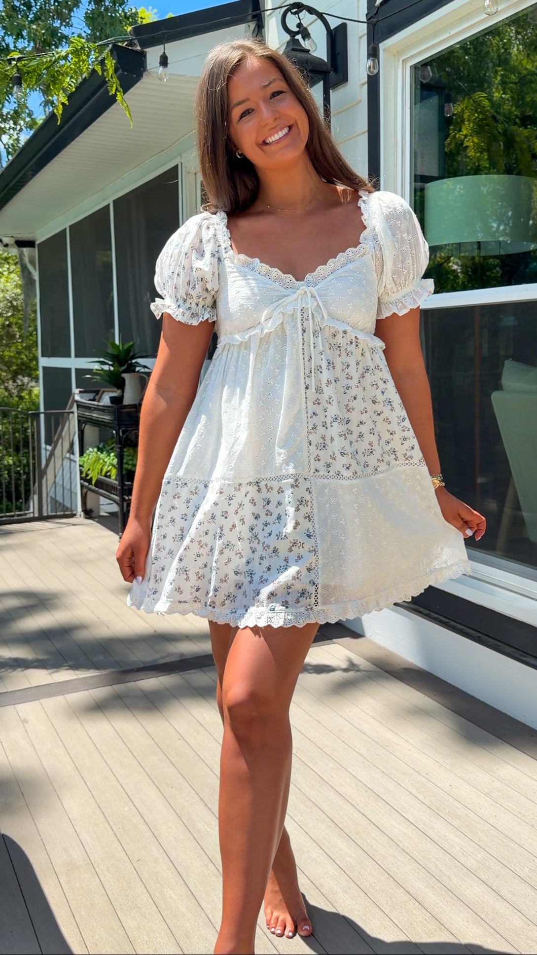 cream floral mini dress with eyelet lace, puff sleeves, scalloped neckline, and front tie detail