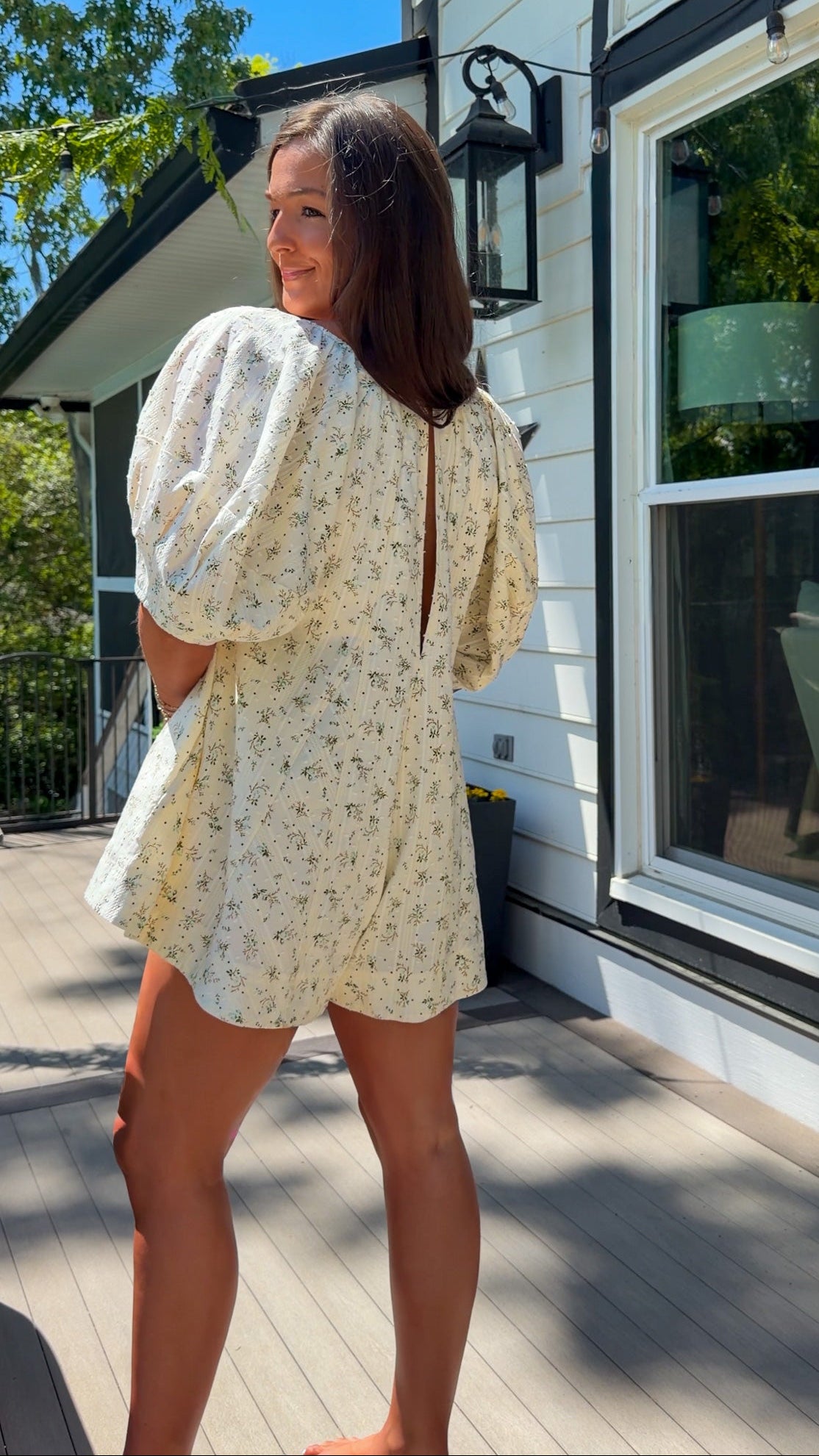 cream floral romper with puff sleeves and green tie neckline, flowy fit with built-in shorts